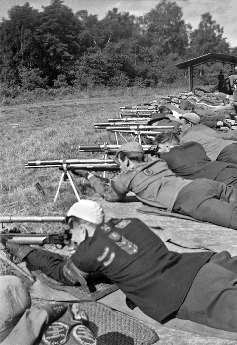 Photograph shows competitors taking aim from their firing points.