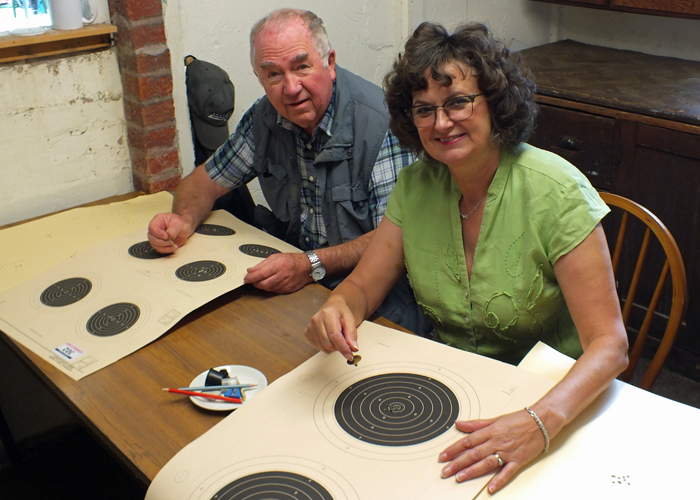 Photograph shows Fred Dukes (pictured left) and Judith Simcock (pictured right) - the Official Scorers busy - assessing the shot targets.