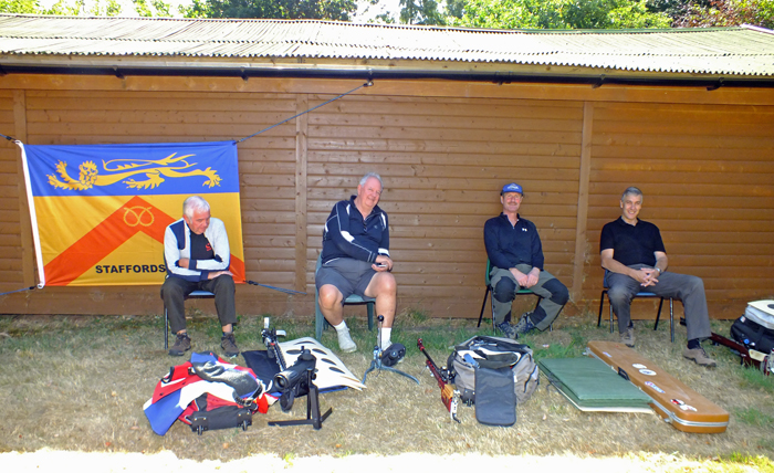 Photograph shows a number of competitors relaxing in the much needed cool shade, after prepping their kit.