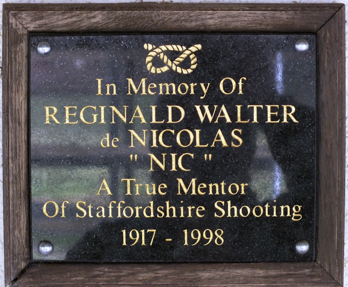 Photograph shows the memorial plaque mounted on the clubhouse wall, dedicated to R.W. de Nicolas.