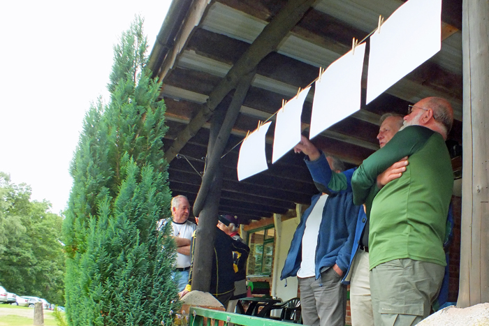 Photograph shows competitors eagerly searching for their results.