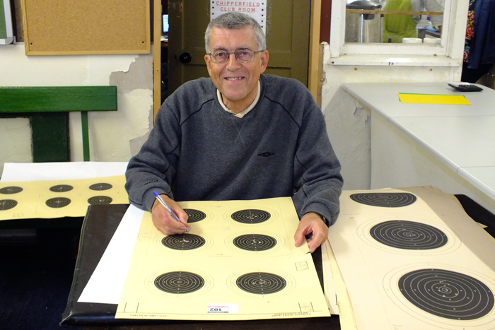 Photograph shows Howard Shorrock - one of a team of official scorers, diligently scrutinising each target.