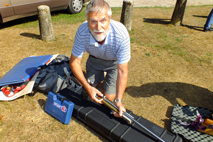 Photograph shows a keen competitor making final adjustments to his rifle.