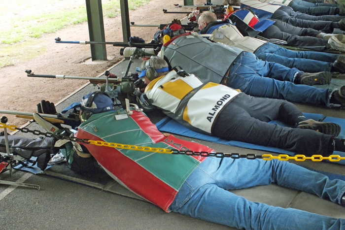 Photograph shows competitors on the firing line, giving it their all as the competition hots up.