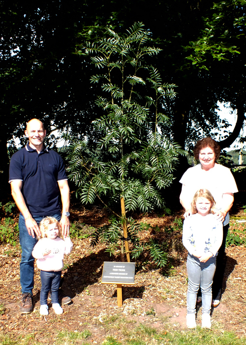 Photograph shows Martin Troke (pictured left) and Janet Troke (pictured right), with Martin's young children, fully refreshed standing alongside the Rowan Tree,  which was planted within the Chipperfield Ranges Complex as a memorial to the late Mr. Fred Troke.