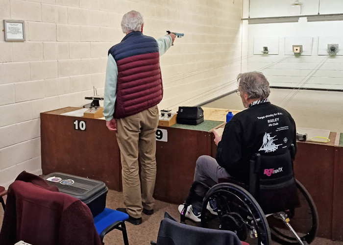 Photograph shows Gary Comer, pictured left, competing on the firing point during the 10 Metres Air Pistol Competition.